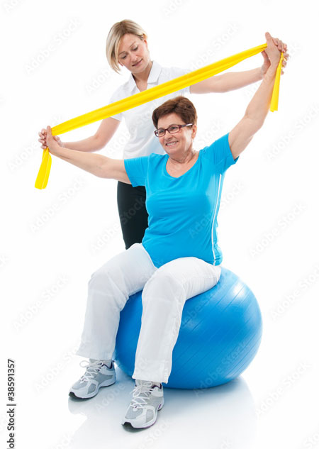 Senior woman working out with a personal trainer using bands