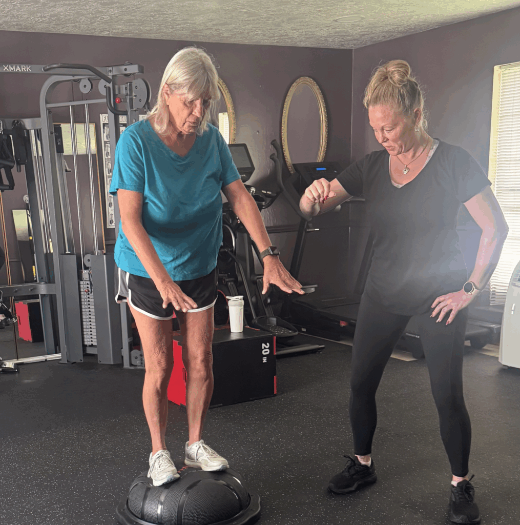 Personal trainer working on a balance exercise with a senior female