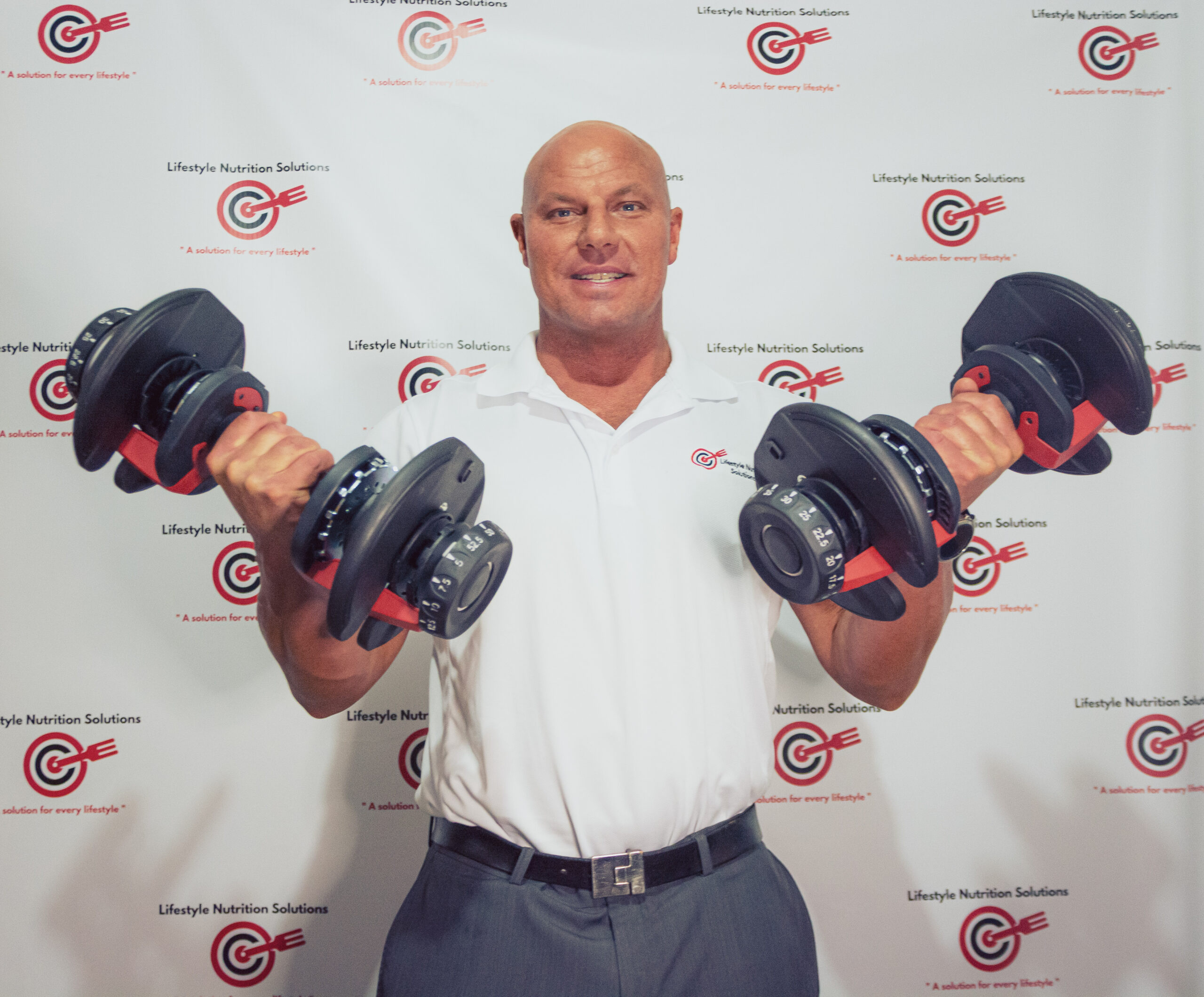 Picture of a personal trainer for seniors in Indianapolis holding weights and smiling at the camera.