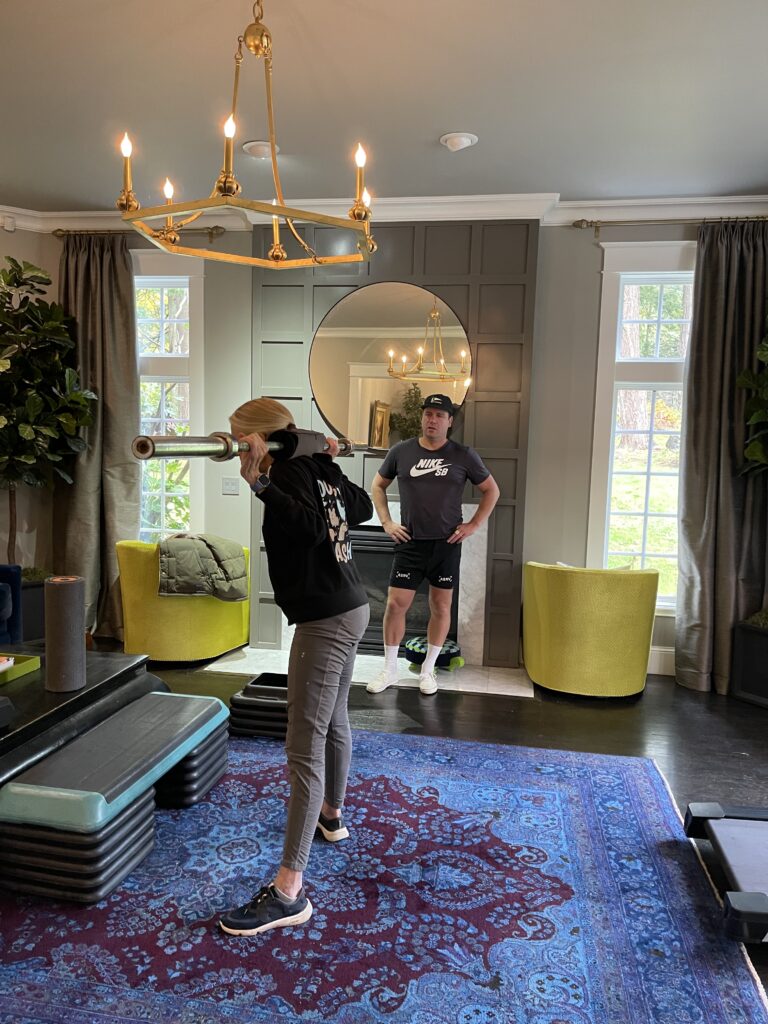 ElderFIT personal trainer for seniors in Portland working with an older female client doing a squat exercise in her home.
