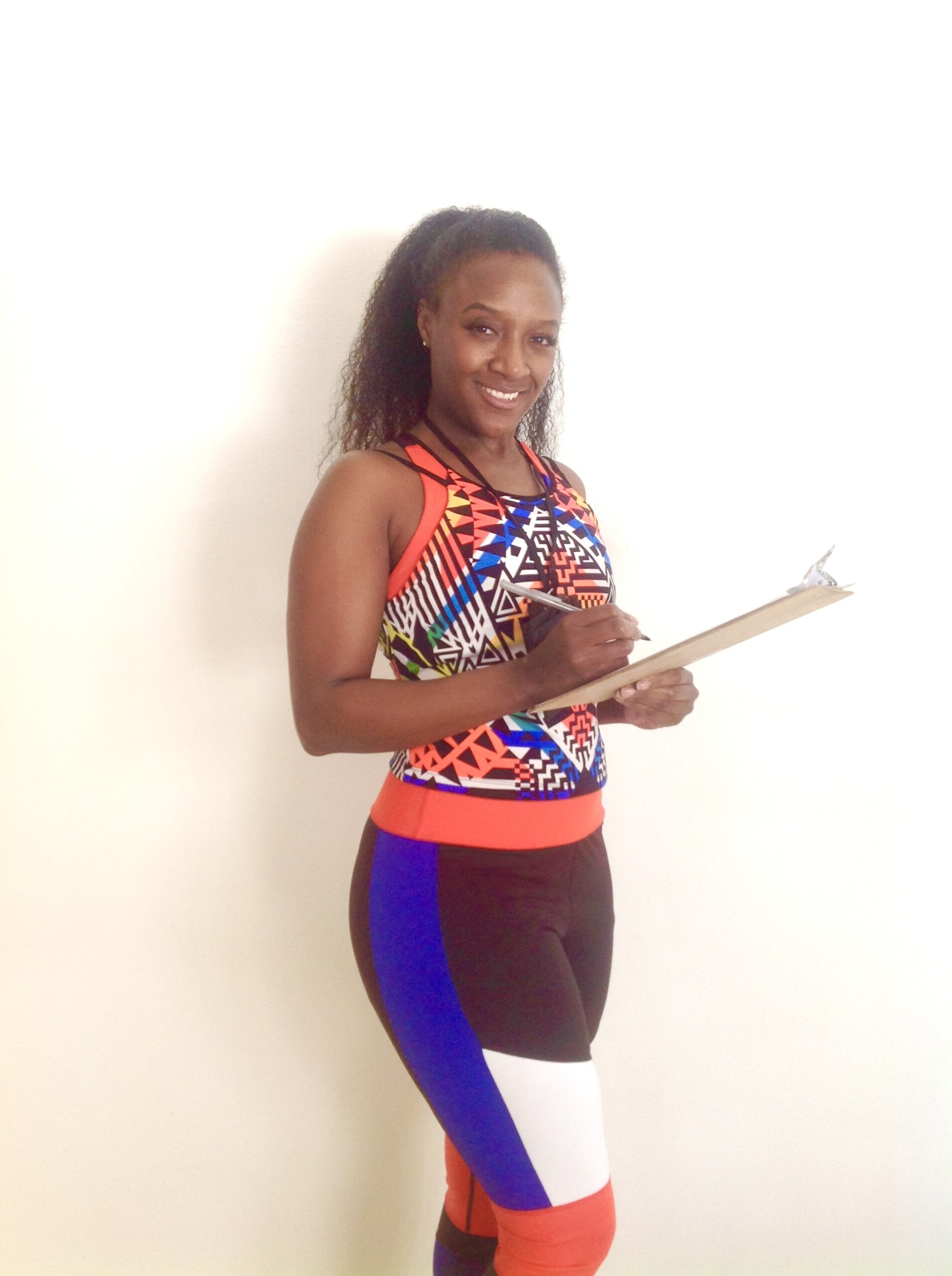 Meet ElderFIT trainer Blenda, a fitness trainer for seniors in Denver standing with a clipboard in her hand smiling.