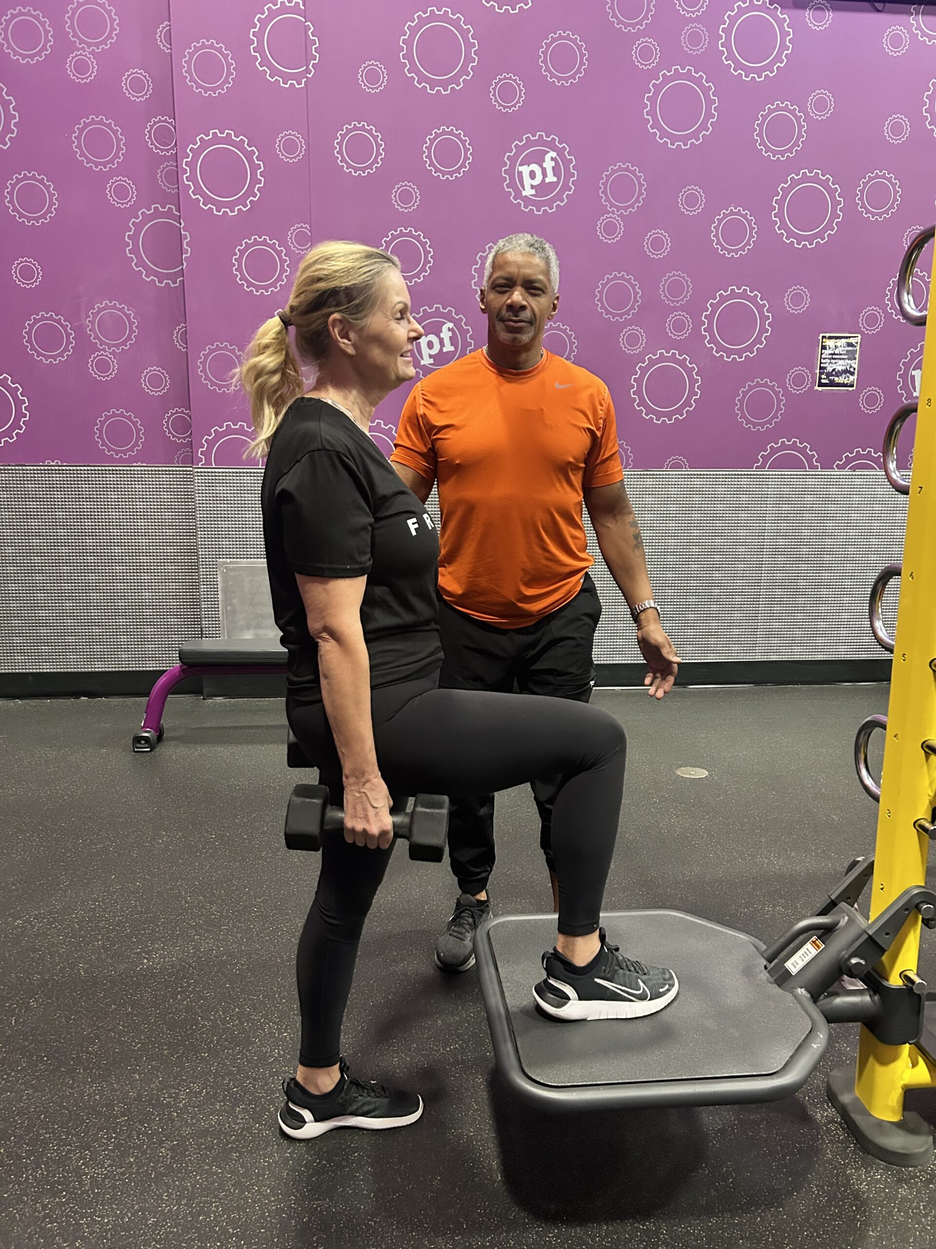 A top personal trainer for seniors in Las Vegas coaching an older female on a workout in a gym.