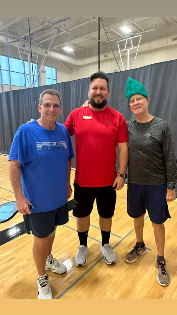 Stephen is a top ElderFIT personal trainer for seniors in The Woodlands and here he is standing in a gym with 2 male senior customers smiling at the camera