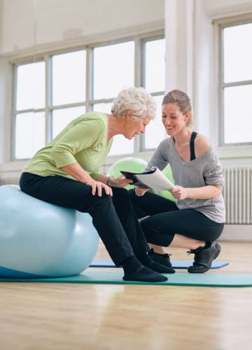 Elder female with trainer doing review